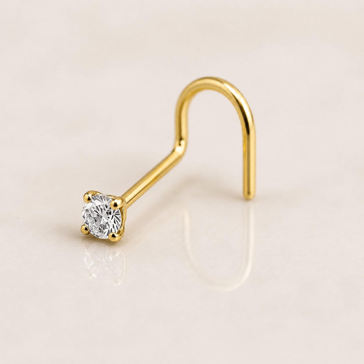 Nose stud en titane doré à tige courbée, zircon blanc rond serti quatre griffes, sur fond beige