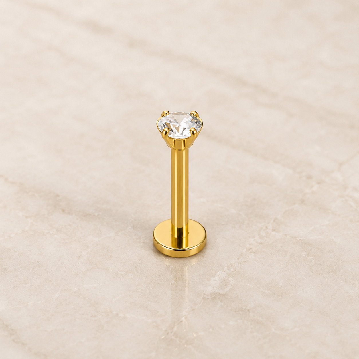 Labret titane doré à vissage interne, zircon cristal 3 mm serti quatre griffes, disque plat, sur fond beige
