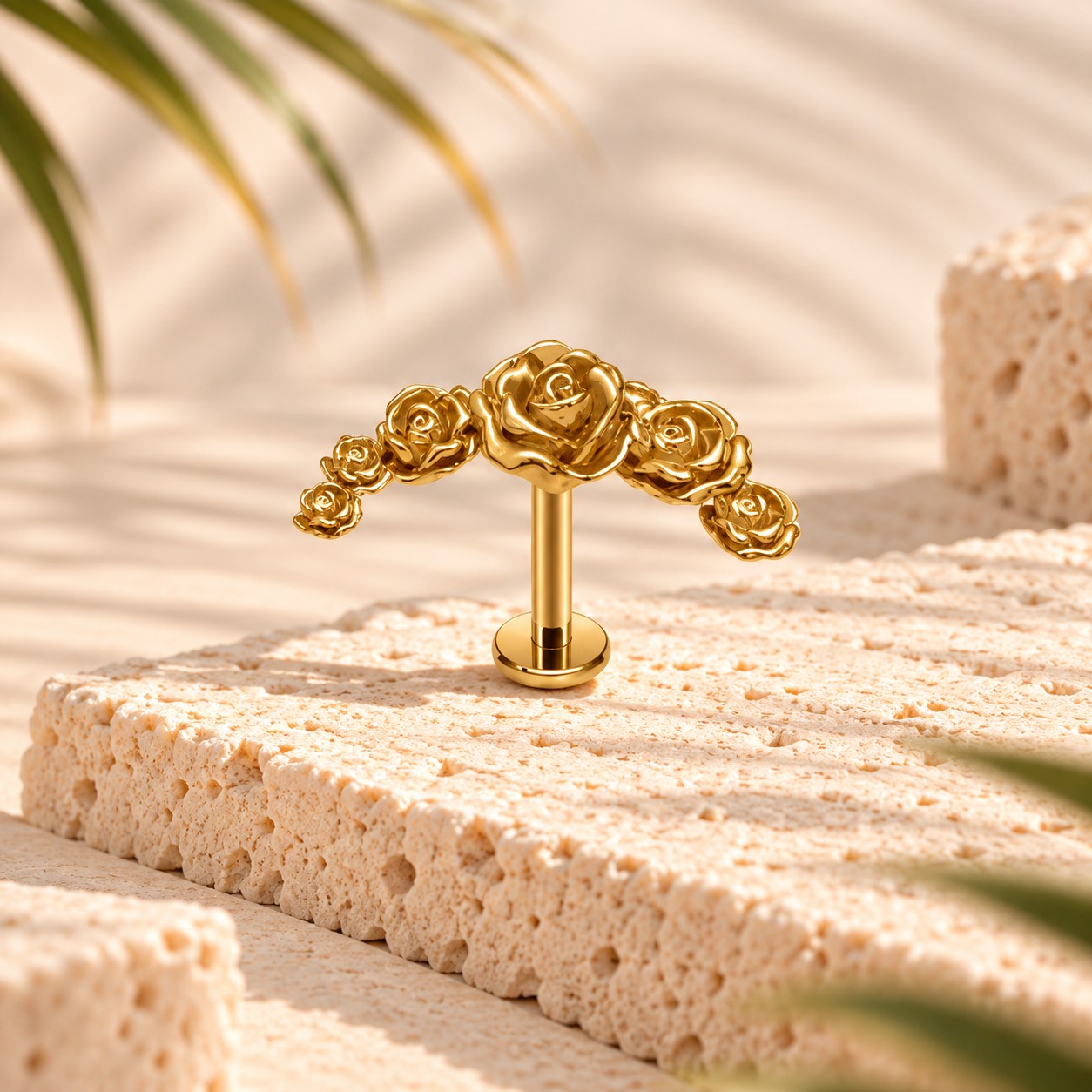 Stud flat back en titane doré orné d'une guirlande de cinq roses en relief, posé sur une pierre claire