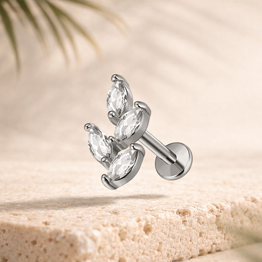 Labret acier argenté motif papillon à quatre pierres marquise, tige 1,2 mm et disque plat, posé sur pierre claire