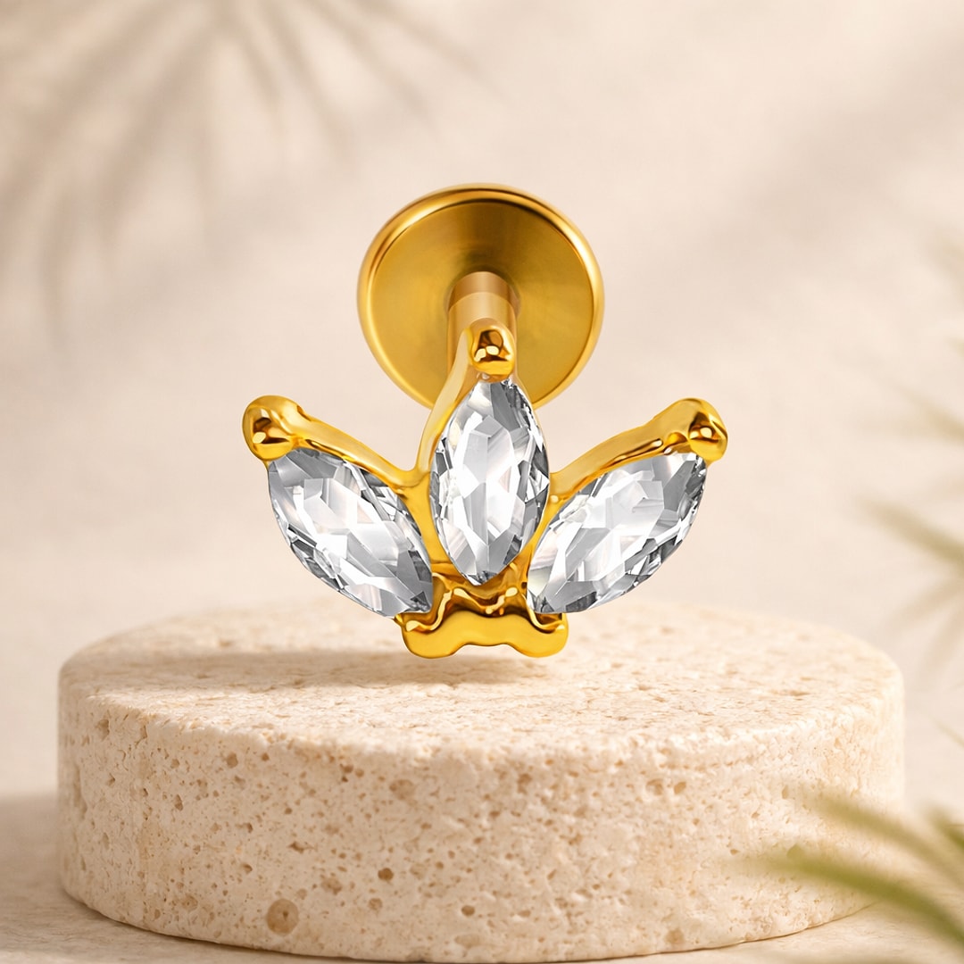 Labret doré à trois cristaux en marquise formant un lotus, base plate ronde, posé sur une pierre claire
