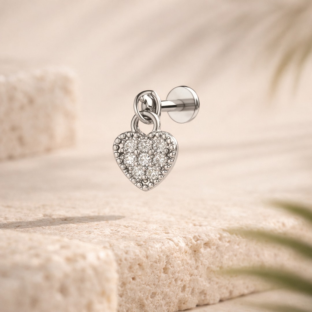 Stud flat back avec pendentif cœur pavé de zircons blancs et tige à visser, posé sur un socle clair