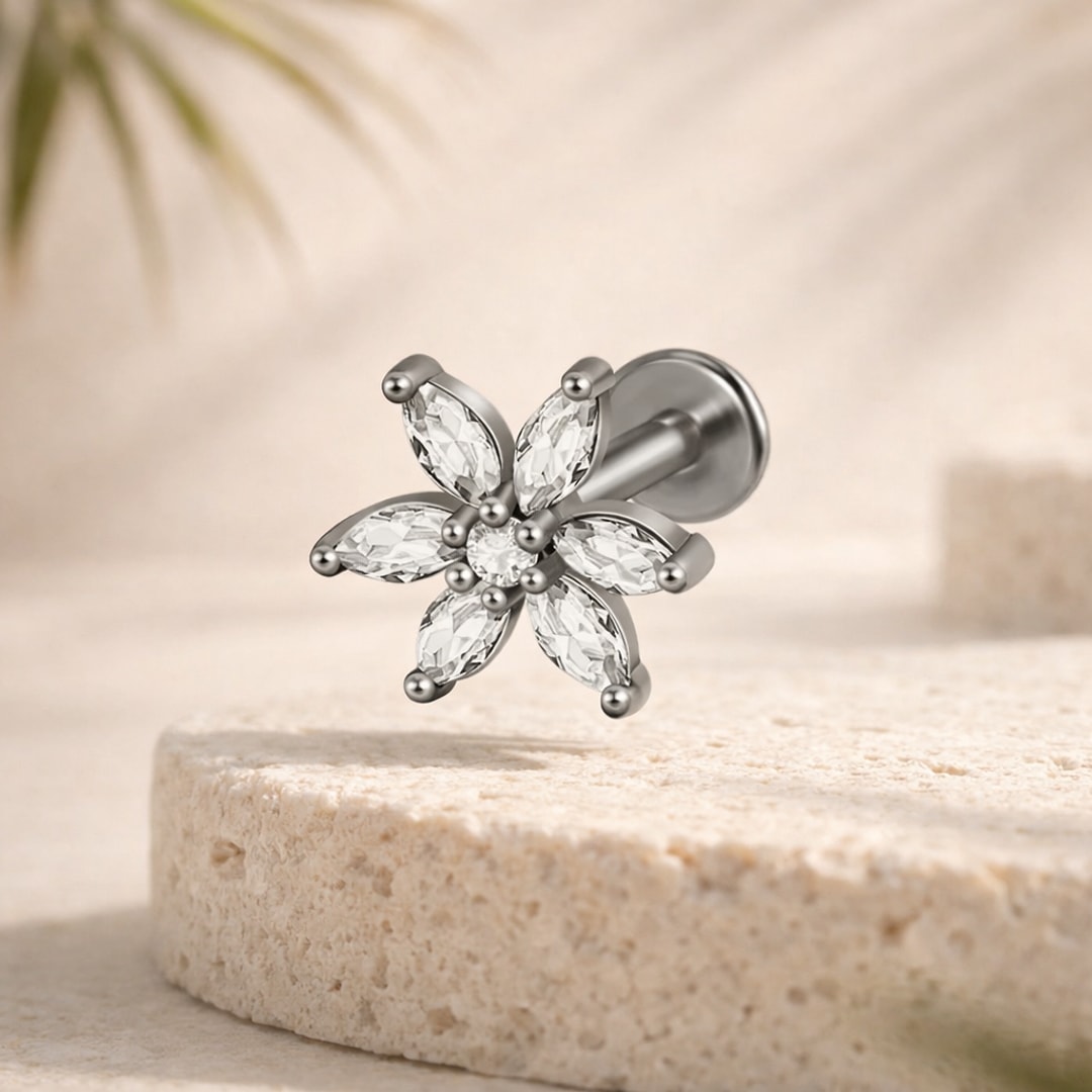 Labret acier argenté motif fleur à six pierres marquise et pierre centrale, base plate, posé sur pierre claire