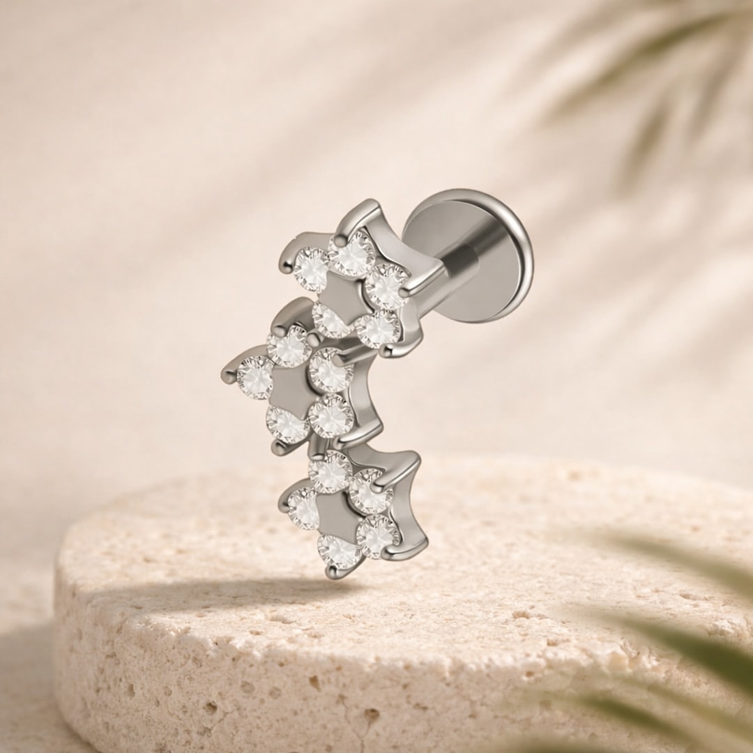 Labret argenté en acier orné de trois étoiles serties de zircons blancs, posé sur une pierre claire