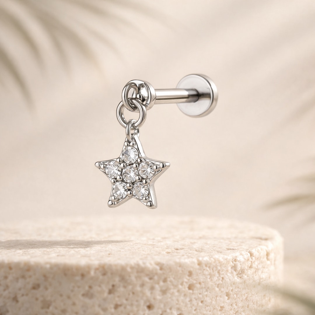 Labret flat back argenté en acier avec pendentif étoile serti de zircons blancs, posé sur une pierre claire