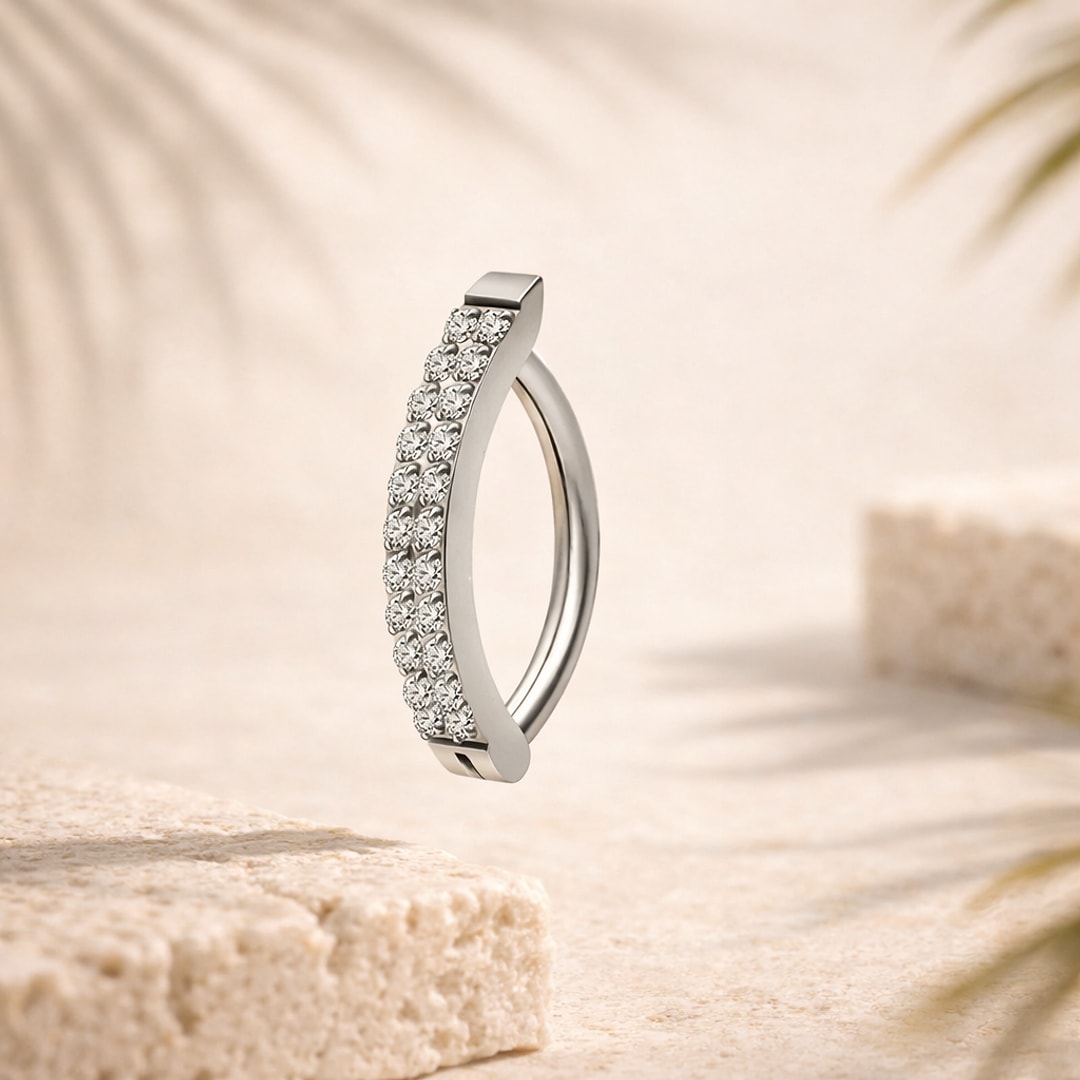 Anneau clicker de nombril en titane argenté avec double rangée de zircons blancs sur fond beige