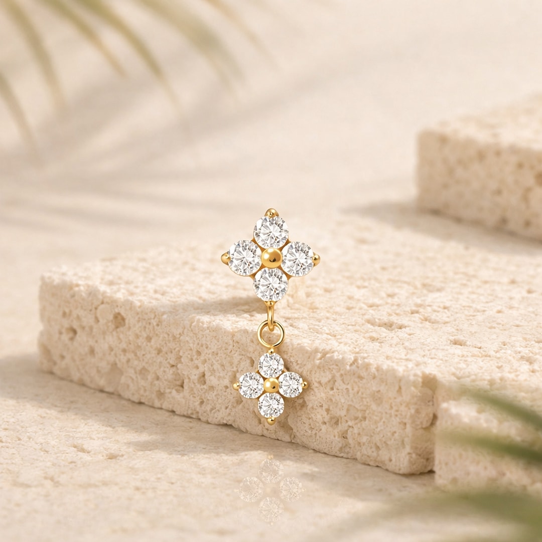 Top piercing titane doré : deux fleurs de zircons blancs reliées par un anneau, pendant sur pierre claire