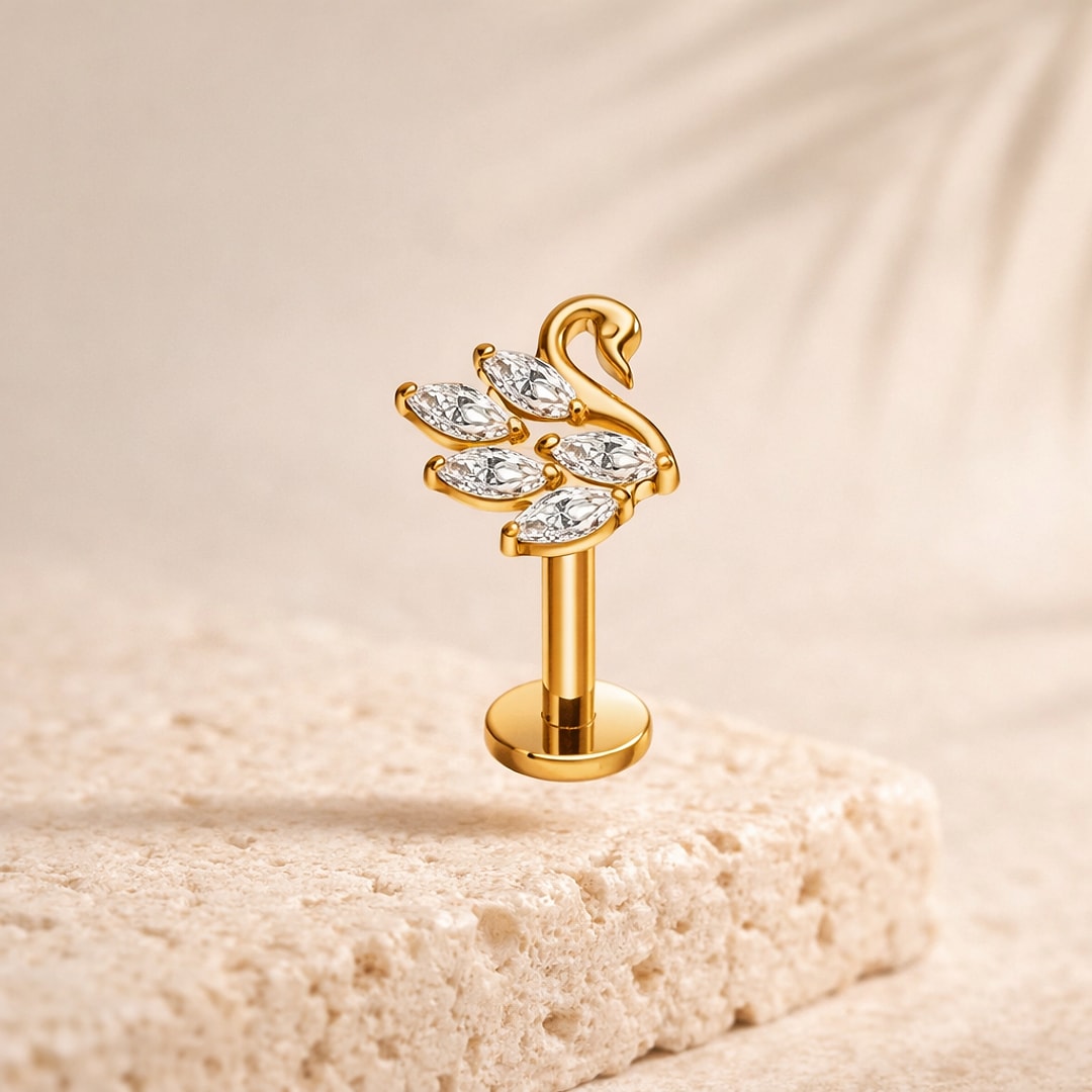 Stud flat back cygne en titane doré serti de quatre pierres claires marquise, posé sur pierre beige