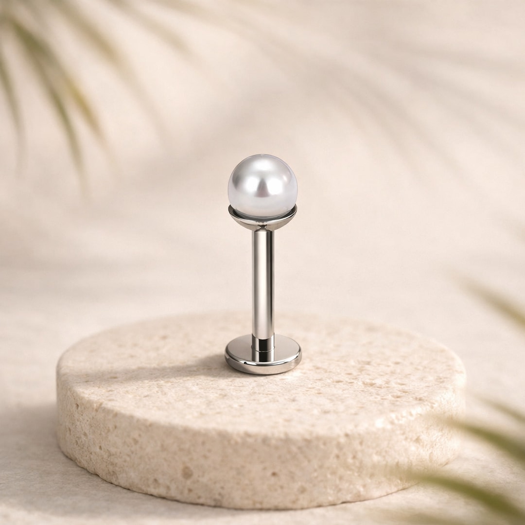 Stud flat back en titane argenté à fausse perle blanche de 5 mm, posé sur une pierre claire