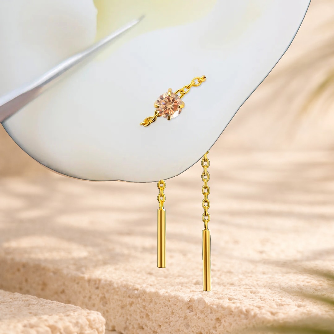 Chaîne d'oreille en titane doré avec zircon rond et deux barrettes pendantes sur fond clair