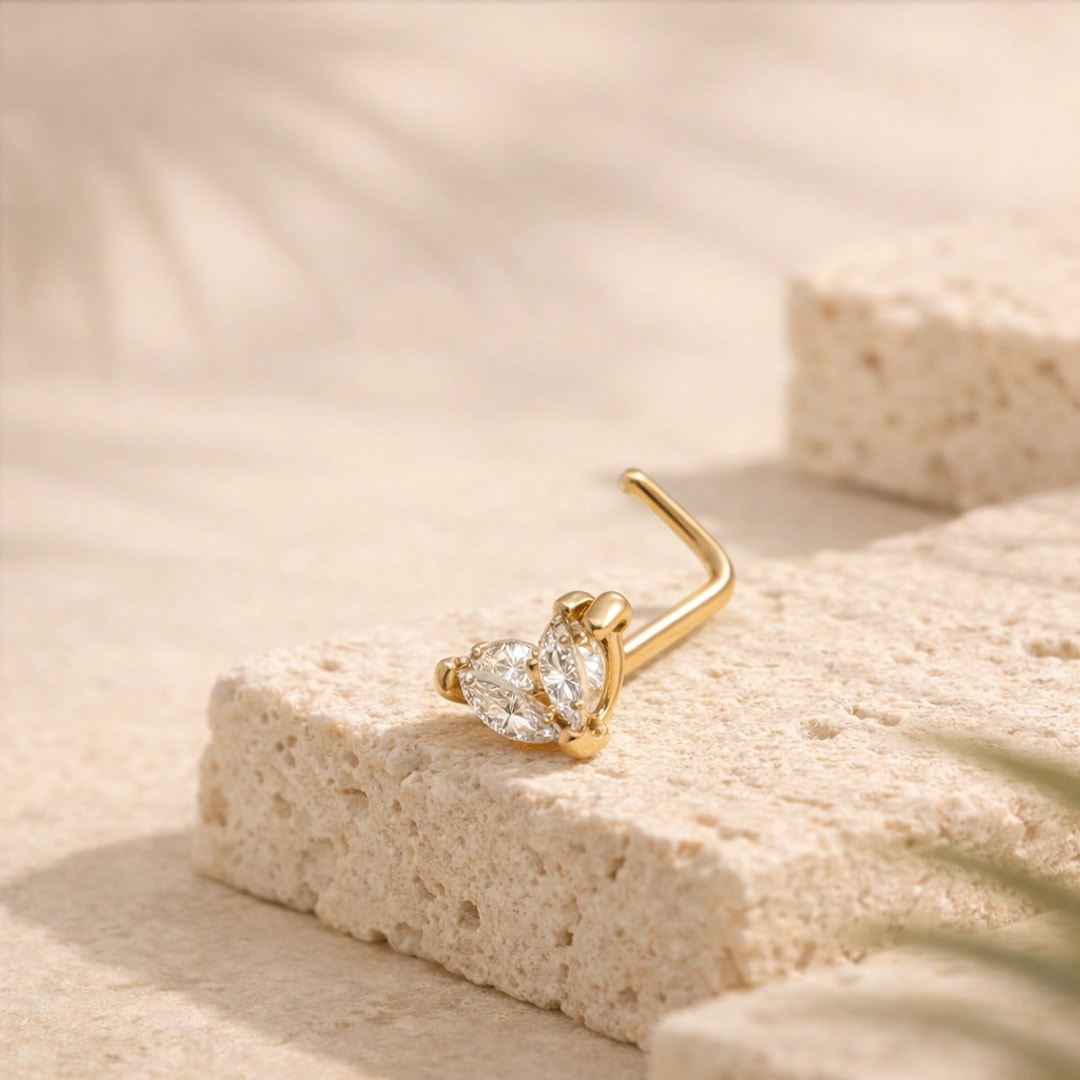 Nose stud acier argenté à tige en L, motif papillon serti de deux zircons, posé sur une pierre claire