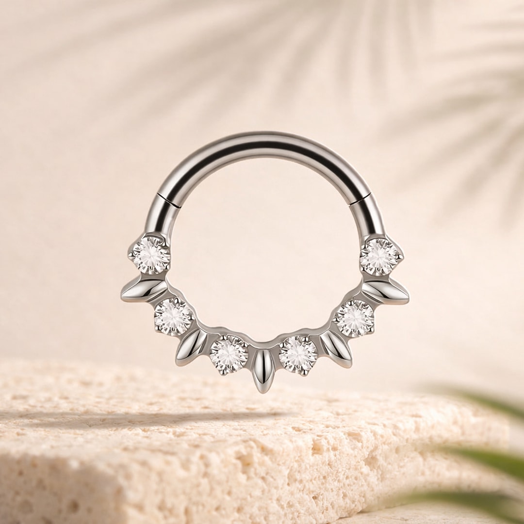 Clicker de septum en titane argenté orné de zircons ronds et de petits pétales, posé sur une pierre claire