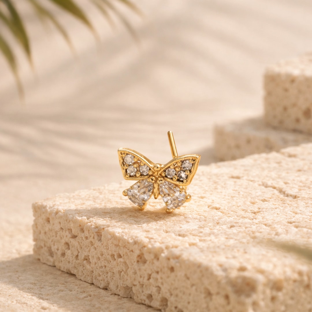 Stud de nez papillon serti de zircons ronds et en gouttes, tige droite, posé sur une pierre claire