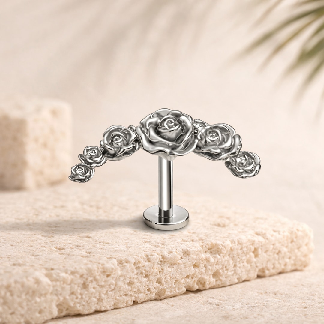 Stud flat back titane argenté en forme de guirlande de roses, posé sur une pierre claire