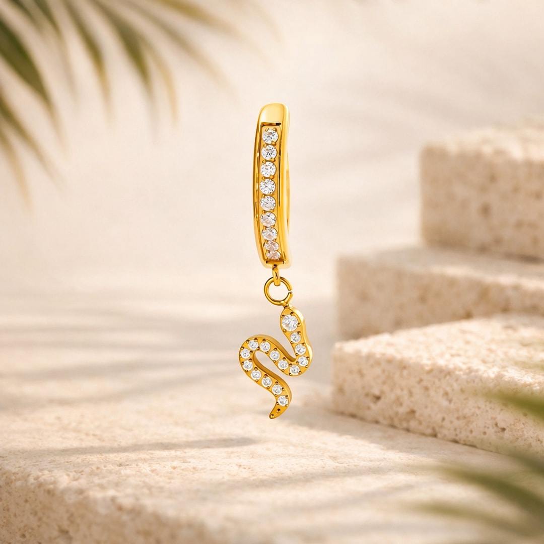 Bijou de nombril en titane doré, arceau serti de zircons blancs et pendentif serpent pavé de pierres