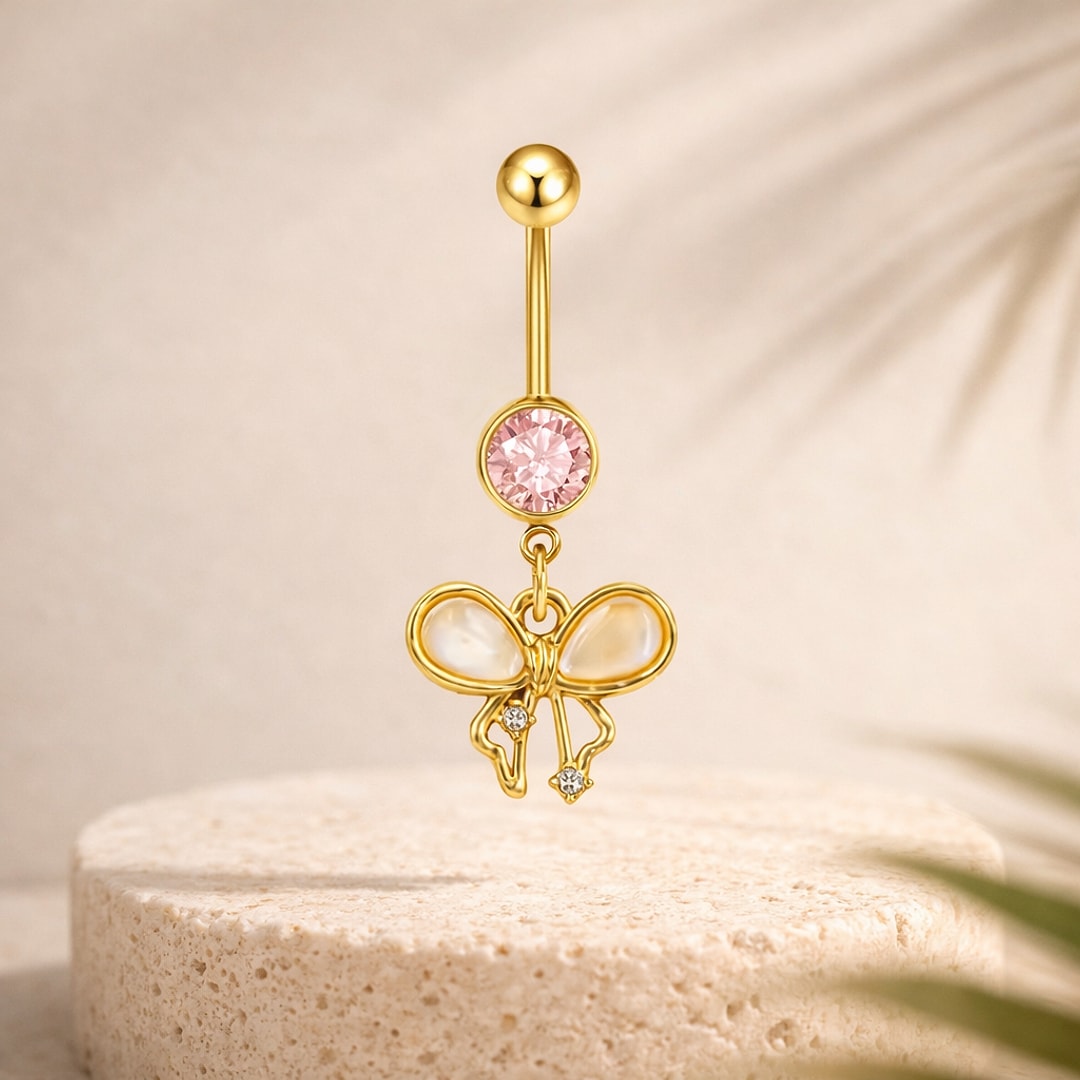 Banane de nombril dorée avec pierre rose et pendentif nœud nacré orné de petits cristaux