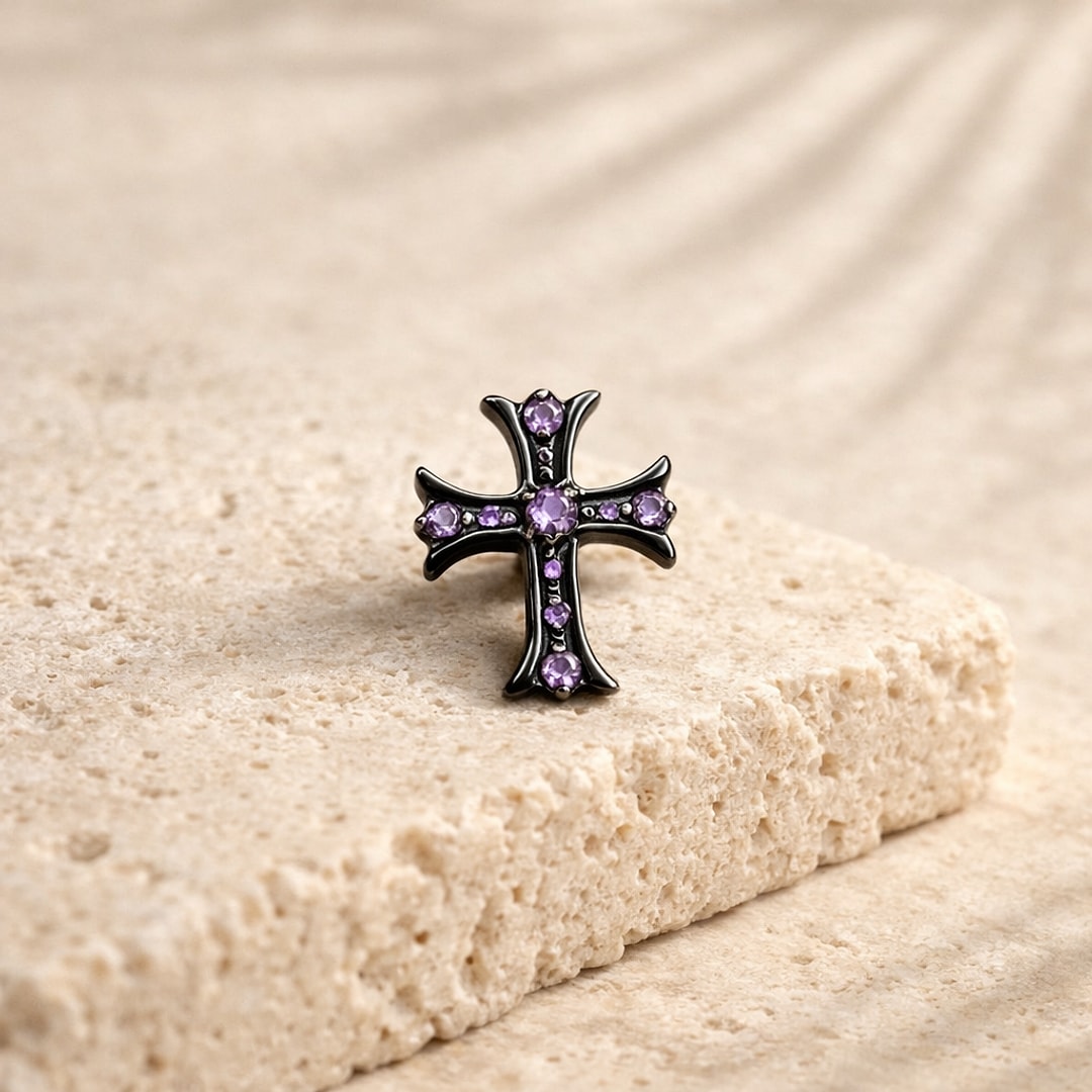 Labret flat back croix gothique en titane noir sertie de zircons violets, posé sur une pierre claire