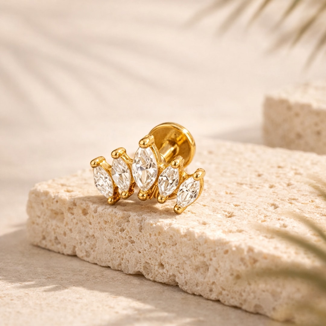 Labret doré orné de cinq zircons blancs taille marquise en couronne, posé sur une pierre claire