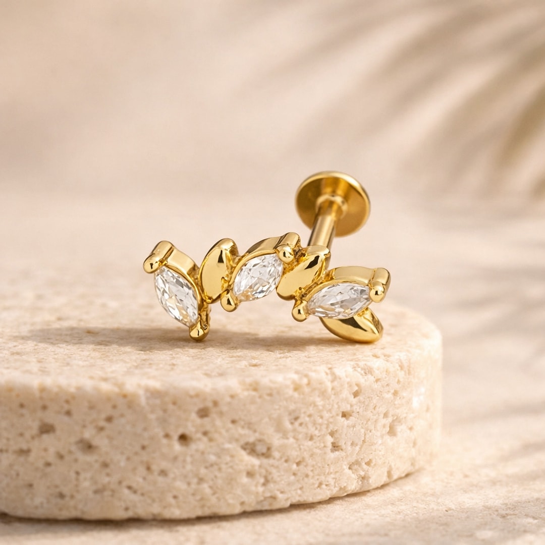 Labret flat back doré avec trois zircons marquise en feuilles, posé sur une pierre claire