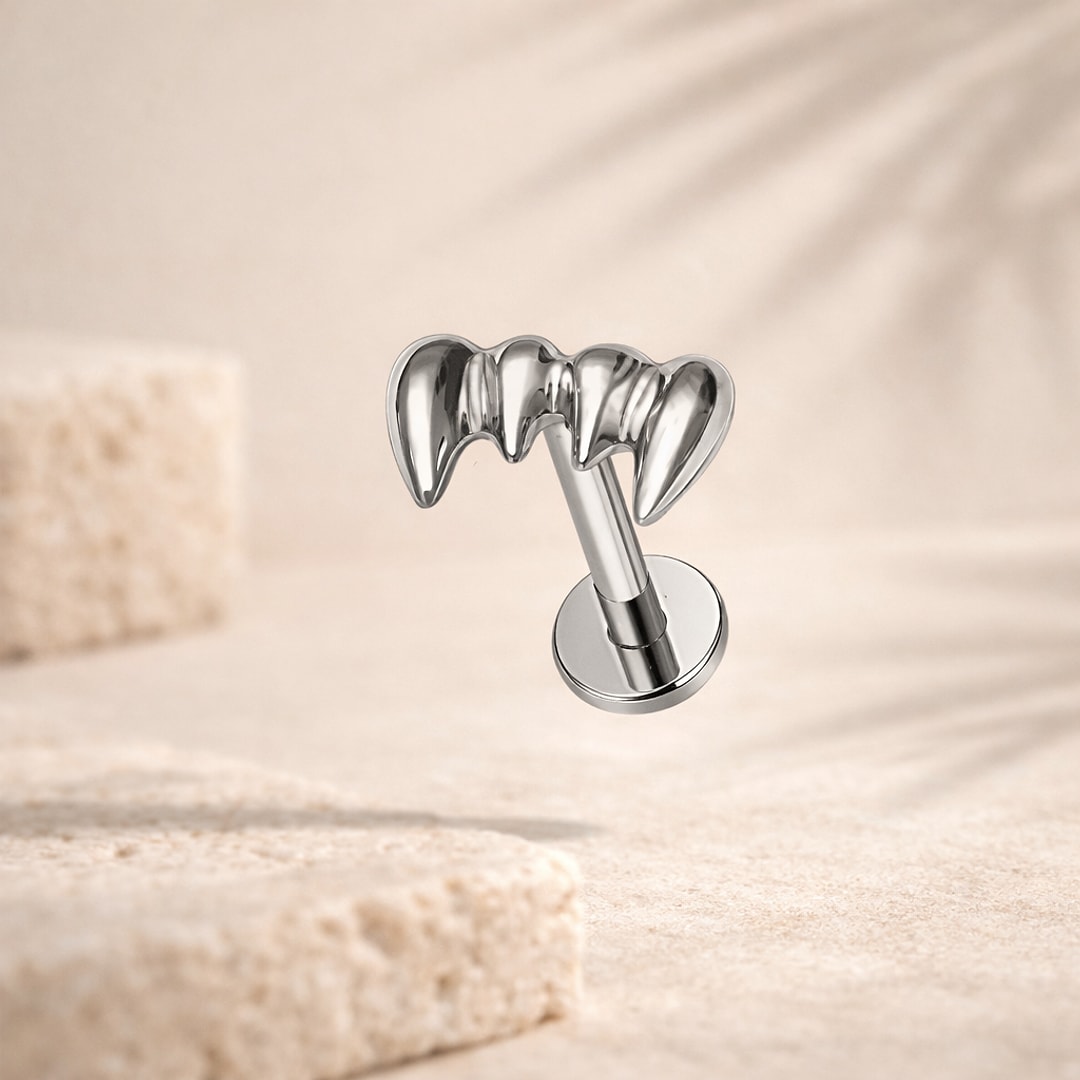 Stud flat back en titane argenté à motif de crocs, tige 1,2 x 8 mm, sur fond beige