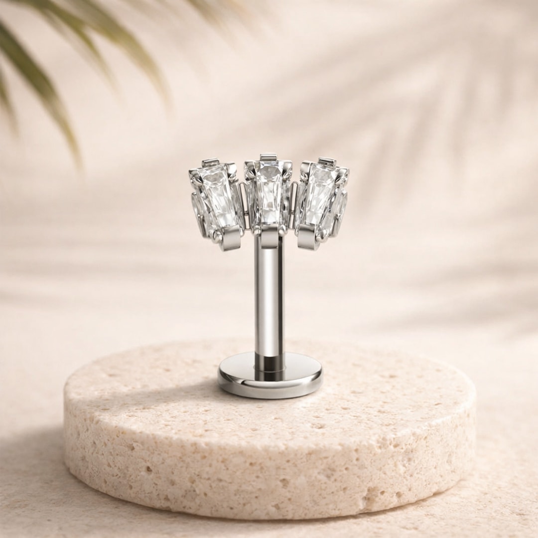 Stud flat back titane argenté avec trois zircons baguette sertis à griffes, tige droite et disque plat, sur pierre claire