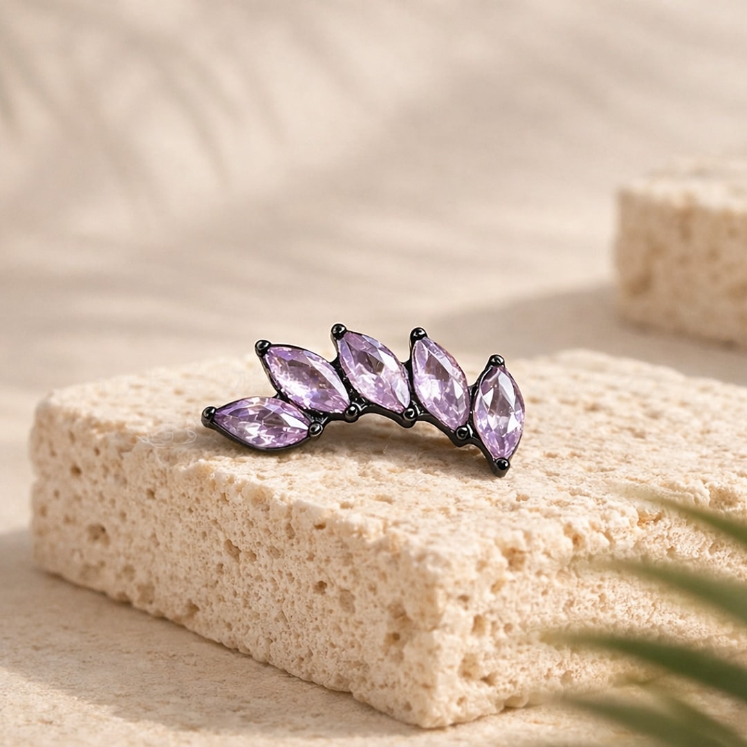 Stud flat back en titane noir orné de cinq zircons violets taille marquise formant une feuille, posé sur une pierre claire
