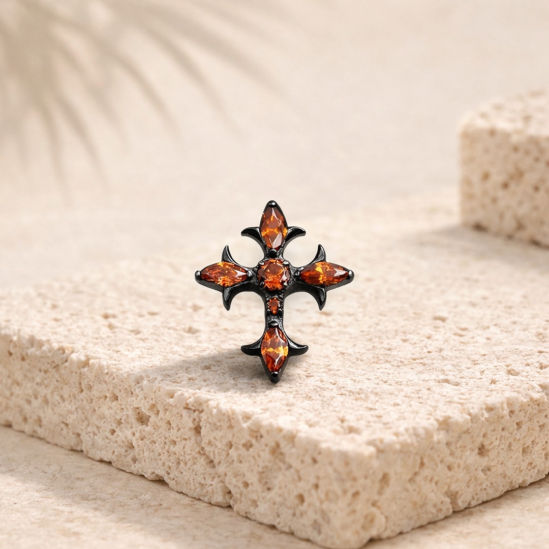 Stud flat back croix gothique en titane noir serti de zircons rouges, posé sur une pierre claire