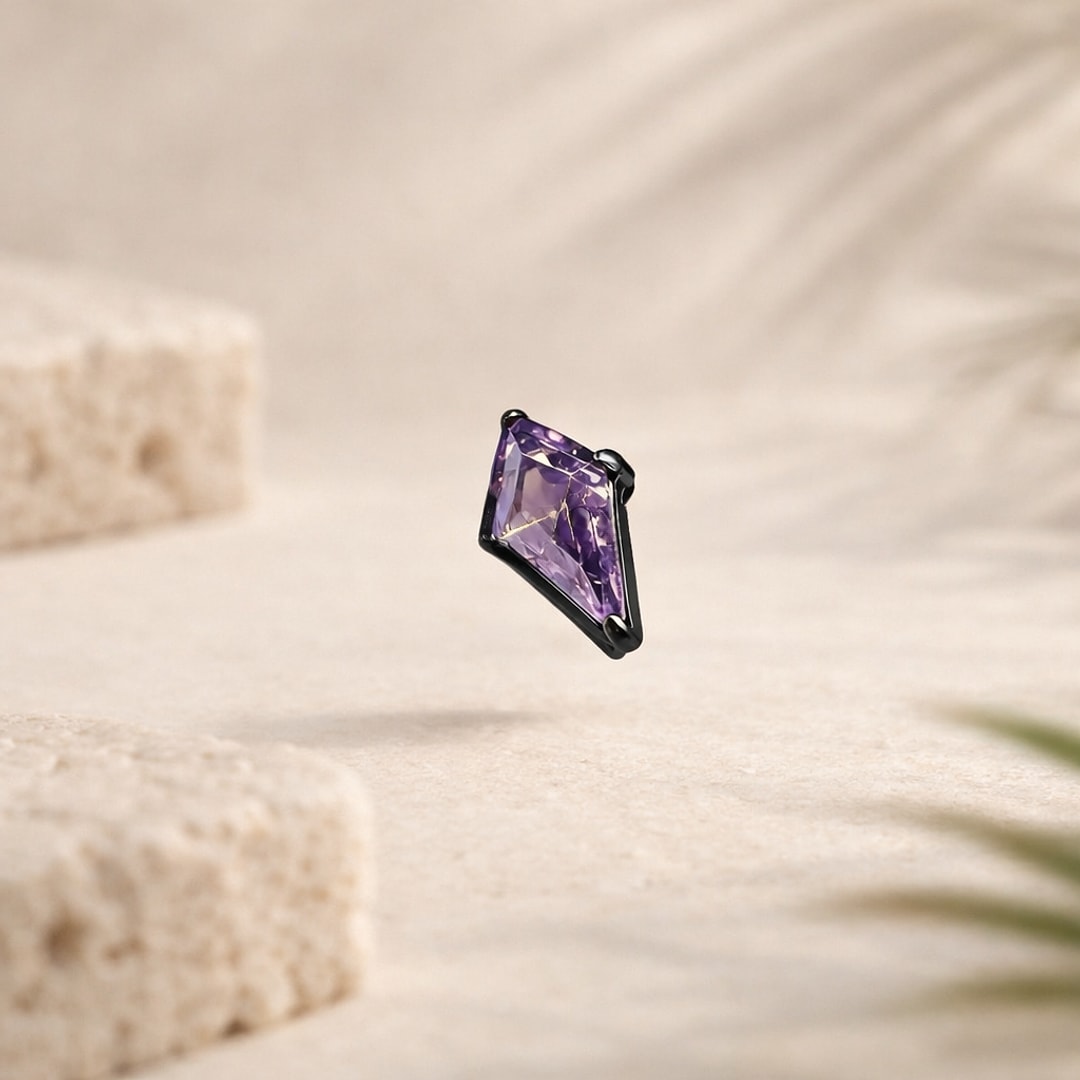 Stud de nez flat back en titane noir serti d'un zircon violet taillé en losange, sur fond beige