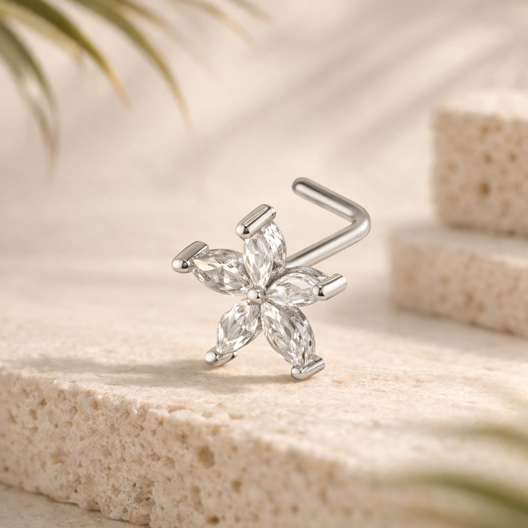 Nose stud en L acier argenté, fleur de cinq zircons marquise sertis griffes, posé sur une pierre claire