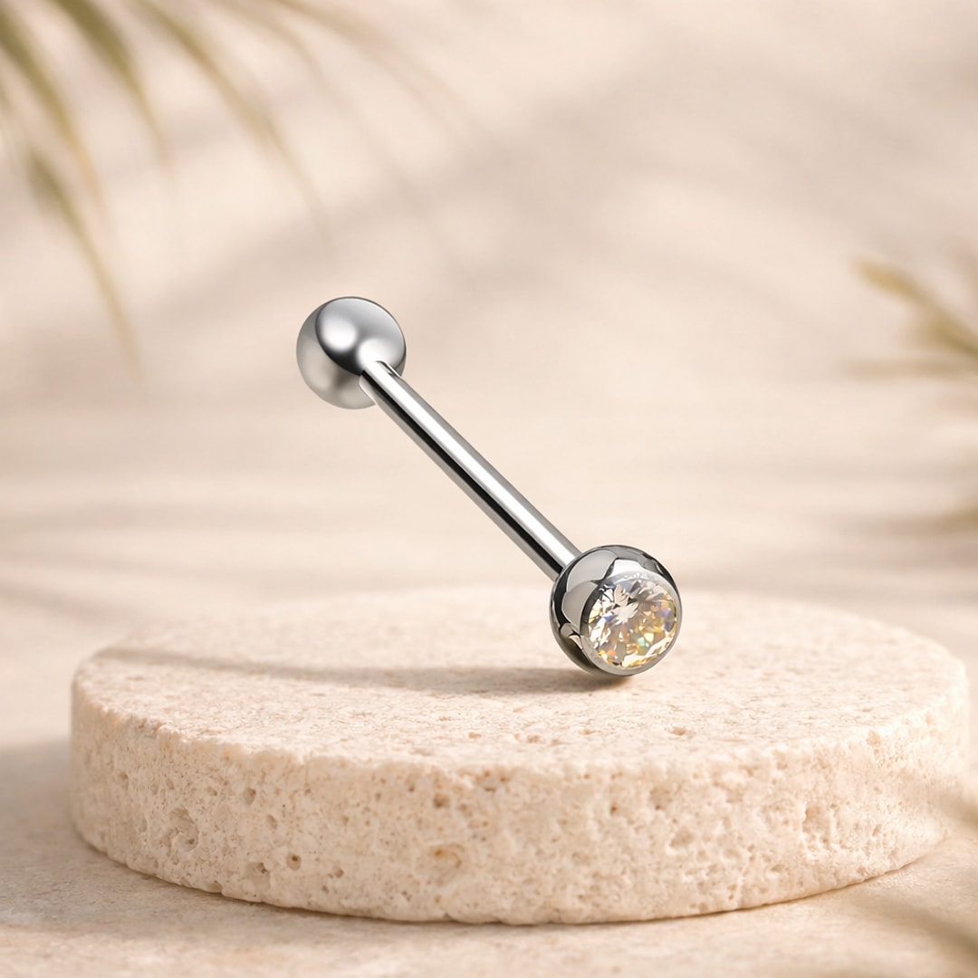 Barre de langue droite en titane avec bille lisse et zircon jaune serti, posée sur une pierre claire