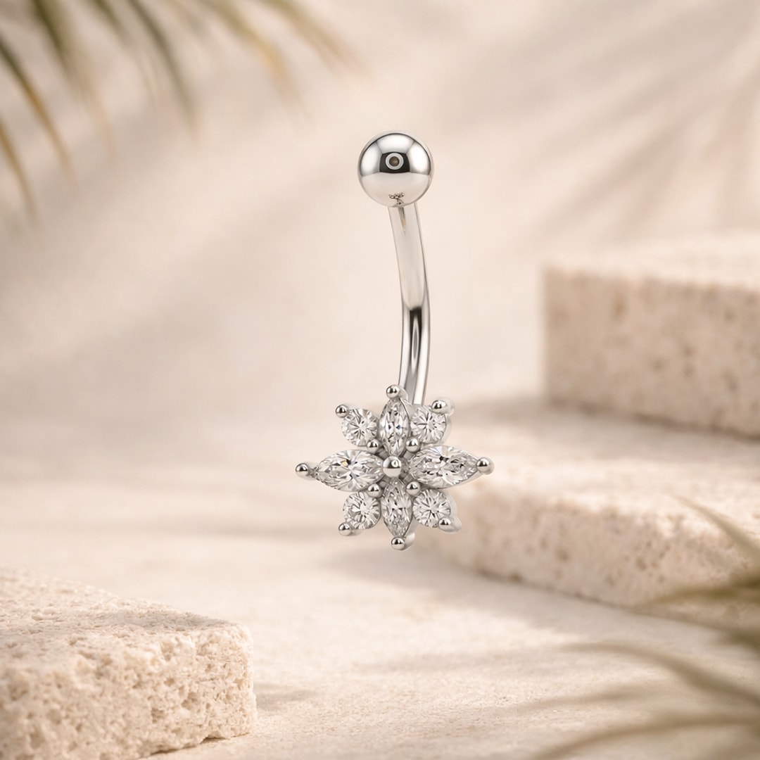 Banane de nombril en acier argenté avec fleur de cristaux taille marquise et ronds, sur fond beige
