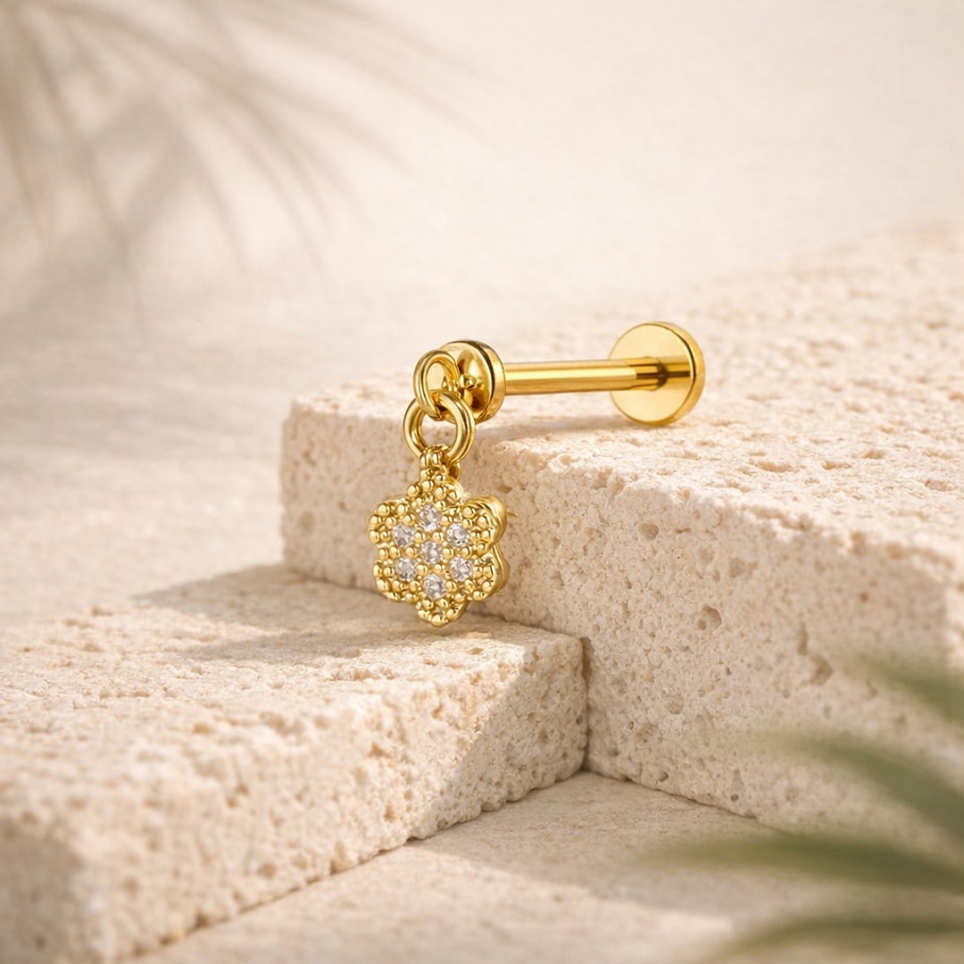 Stud flat back doré avec pendentif fleur serti de cristaux, barre acier 1,2 x 8 mm posée sur pierre claire