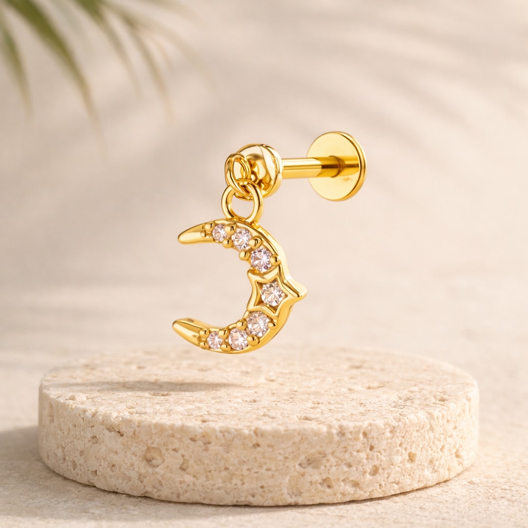 Stud flat back avec pendentif croissant de lune pavé de pierres et étoile centrale, posé sur une pierre claire
