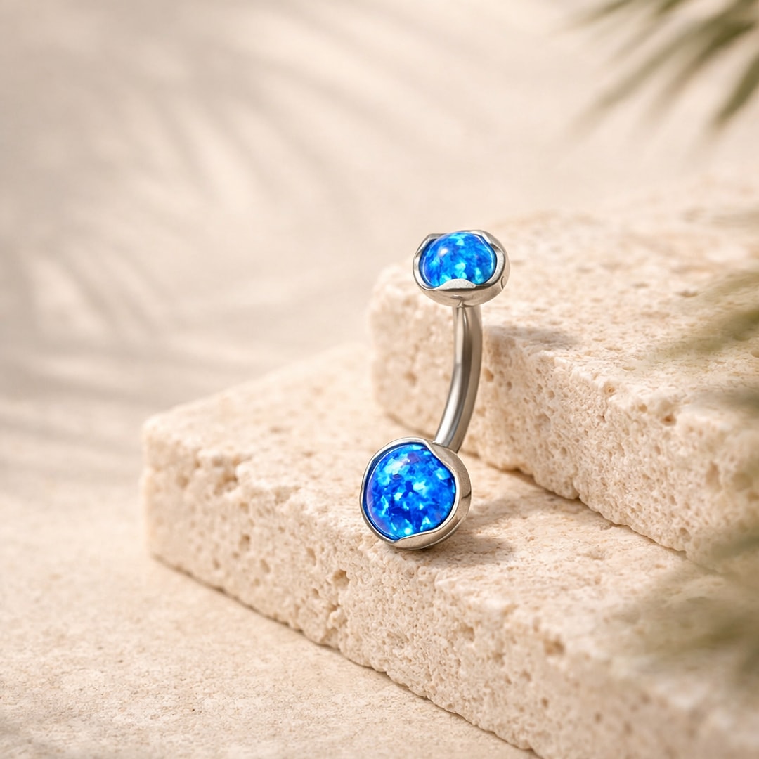 Banane de nombril en titane argenté avec deux cabochons opale bleue sertis, posés sur pierre claire