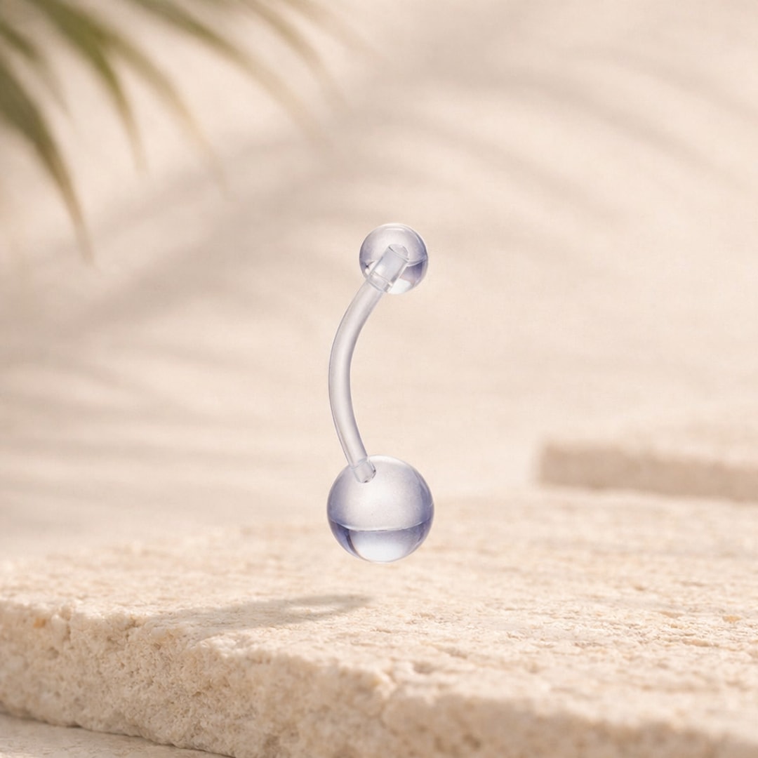 Rétainer banane en acrylique transparent avec deux billes, posé sur une pierre claire
