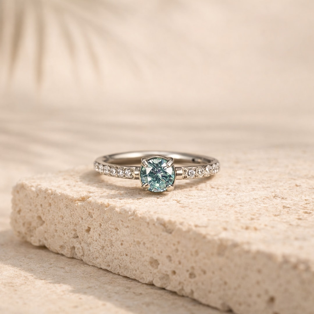 Anneau clicker en titane argenté avec zircon rond bleu serti griffes et pavage de petites pierres claires