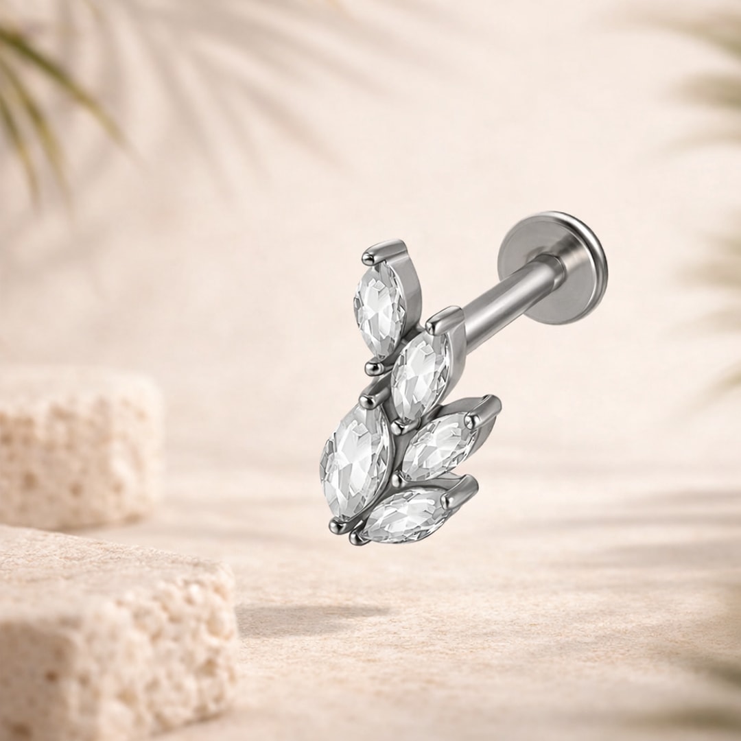 Labret acier argenté avec cinq cristaux taille marquise en éventail, disque plat et barre droite, sur fond beige