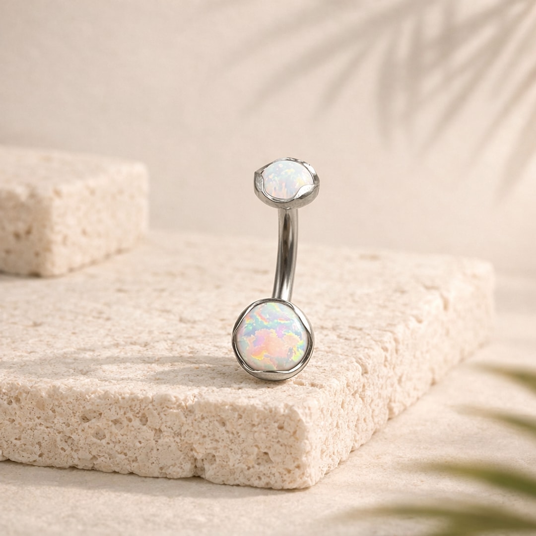 Banane de nombril en titane argenté avec deux cabochons opale blanche irisée sertis bord ondulé