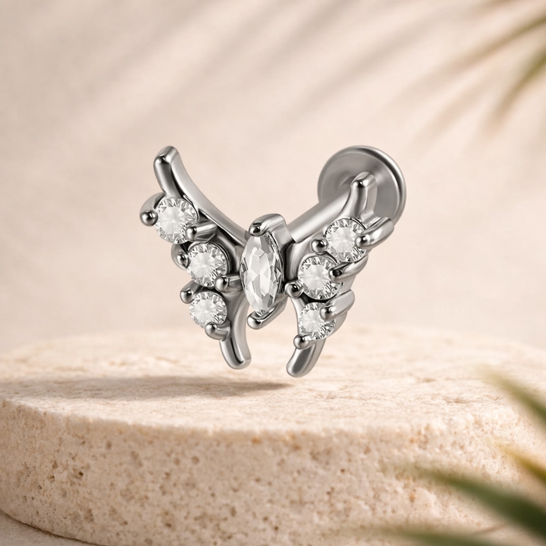 Labret papillon argenté en acier, pierre navette blanche au centre et six cristaux ronds sur les ailes