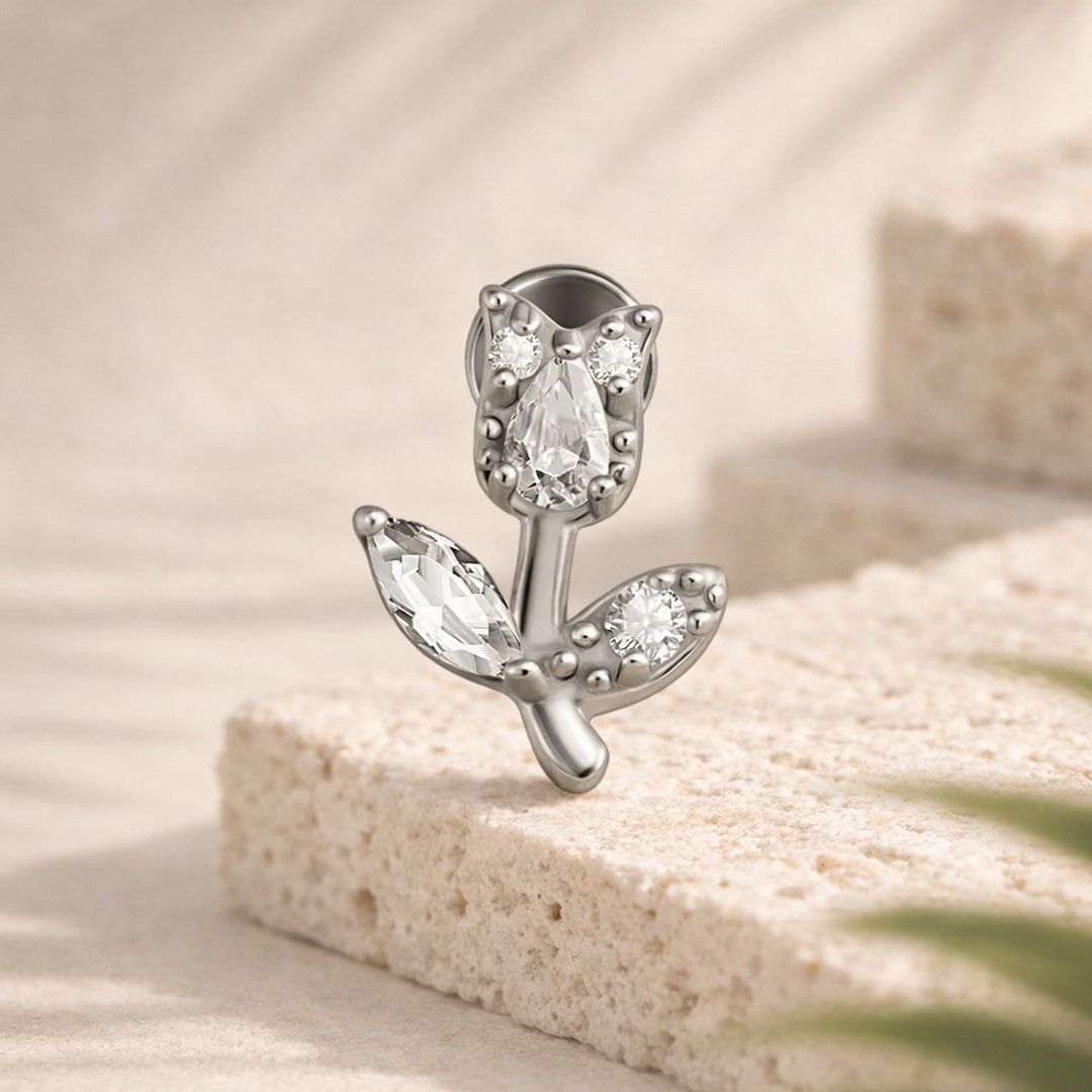 Labret acier argenté motif tulipe serti de zircons goutte, marquise et ronds, posé sur une pierre claire
