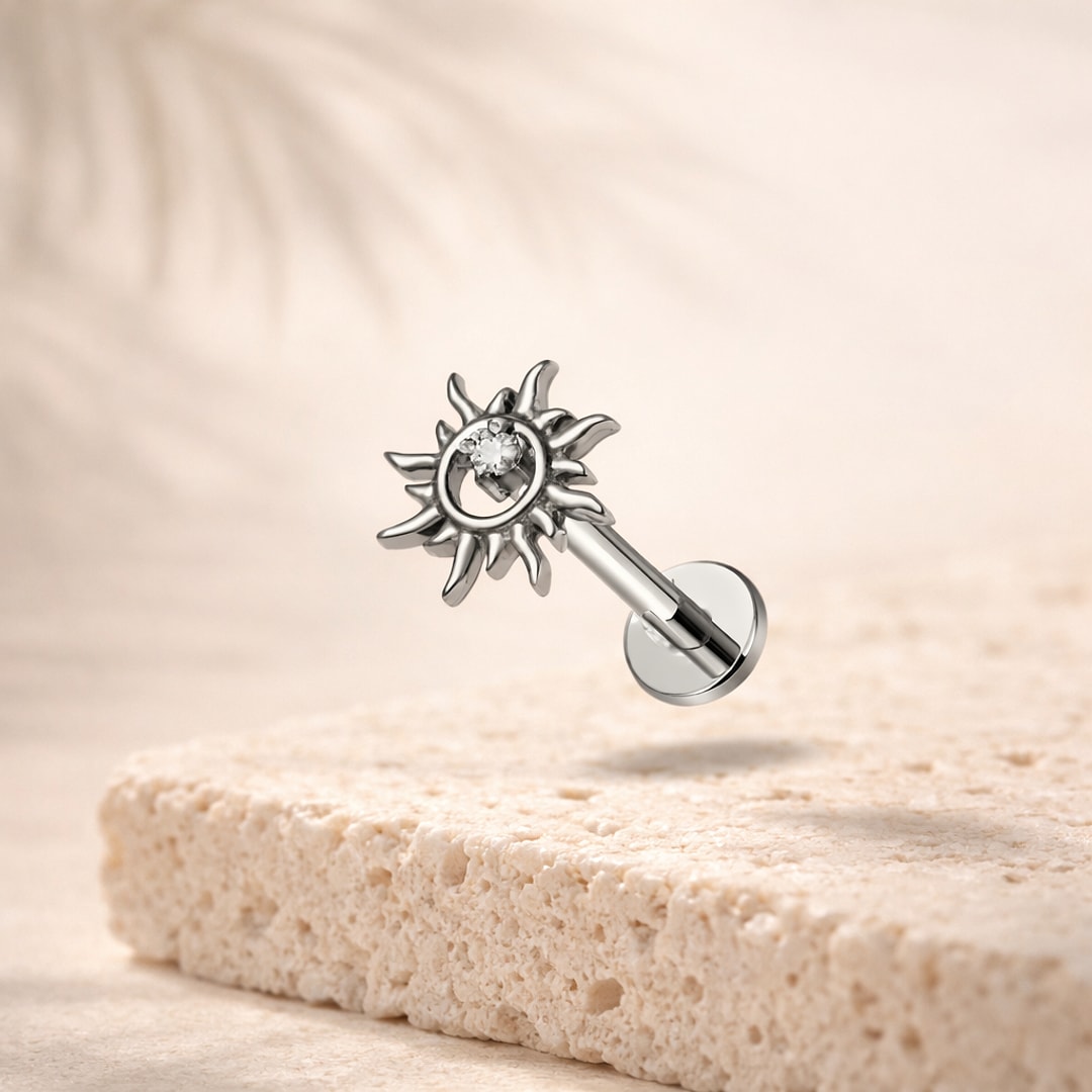 Stud flat back tournesol en titane argenté avec zircon central, tige 1,2 x 8 mm, posé sur une pierre claire