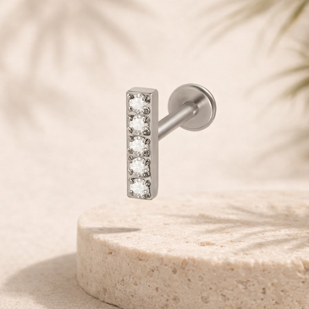 Labret acier argenté à barrette verticale sertie de cinq cristaux blancs, tige droite et disque plat