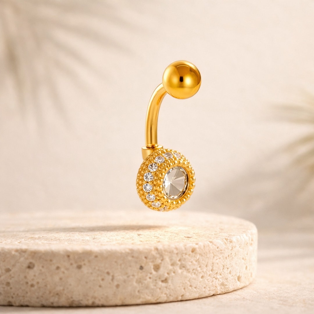 Banane de nombril acier doré, dôme perlé serti d'un cristal central et d'une ligne de petites pierres, bille dorée