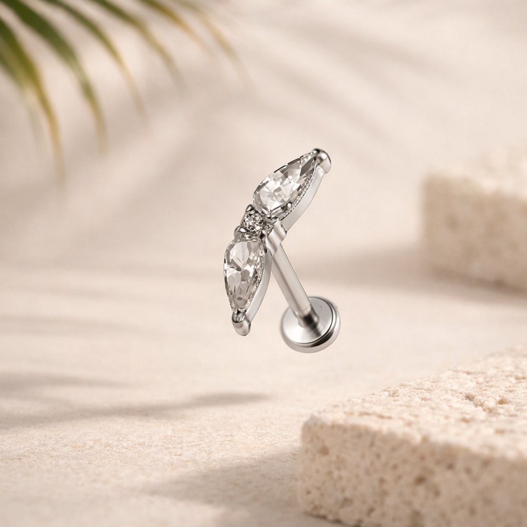 Stud flat back en titane argenté avec deux zircons taille poire et un petit zircon rond, tige droite et disque plat