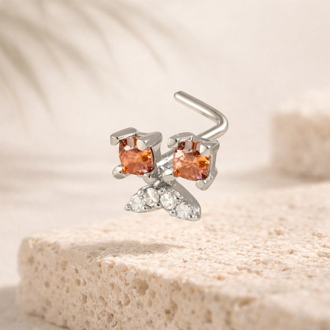 Stud de nez en L acier argenté en forme de papillon, ailes zircon orange et blanc, posé sur pierre claire