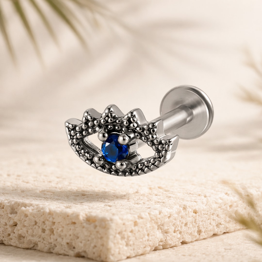 Labret acier argenté motif œil granulé serti d'un zircon rond bleu, tige droite à disque plat