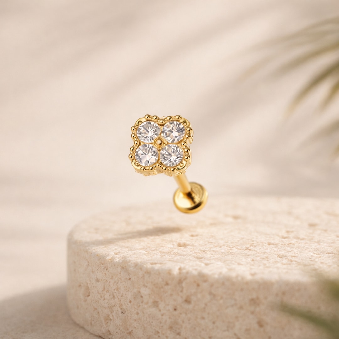 Stud flat back titane doré motif trèfle serti de quatre zircons blancs, posé sur une pierre claire