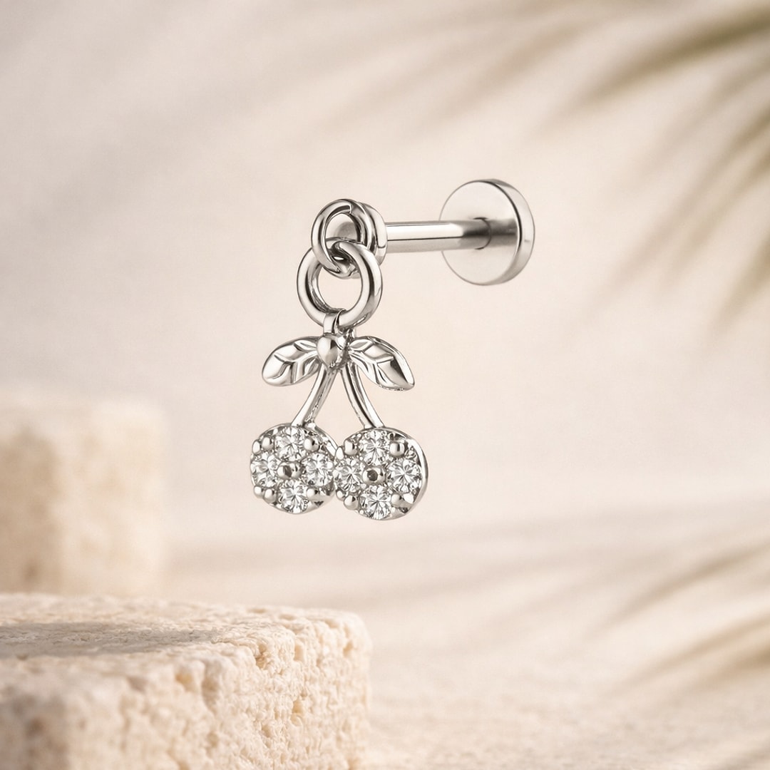 Stud flat back avec pendentif cerise serti de zircons et feuilles, posé sur une pierre claire