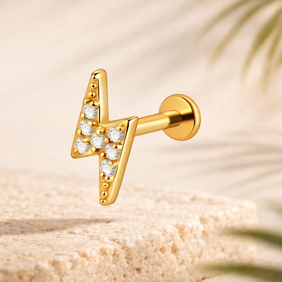 Labret doré en forme d'éclair serti de zircons blancs, tige droite et disque plat, posé sur une pierre claire