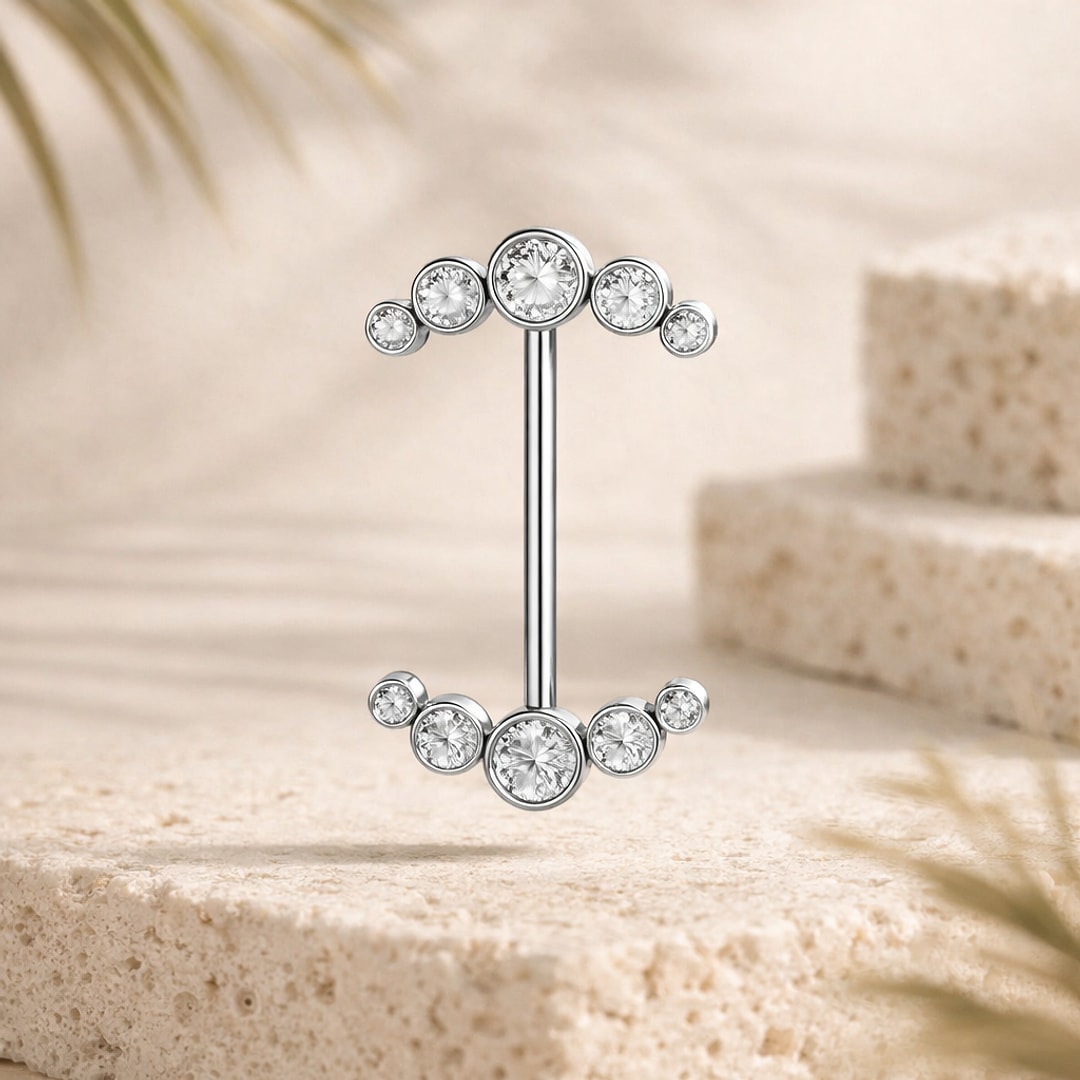 Barbell de téton en titane argenté avec deux arcs de cinq zircons clairs sertis clos, posé sur pierre claire